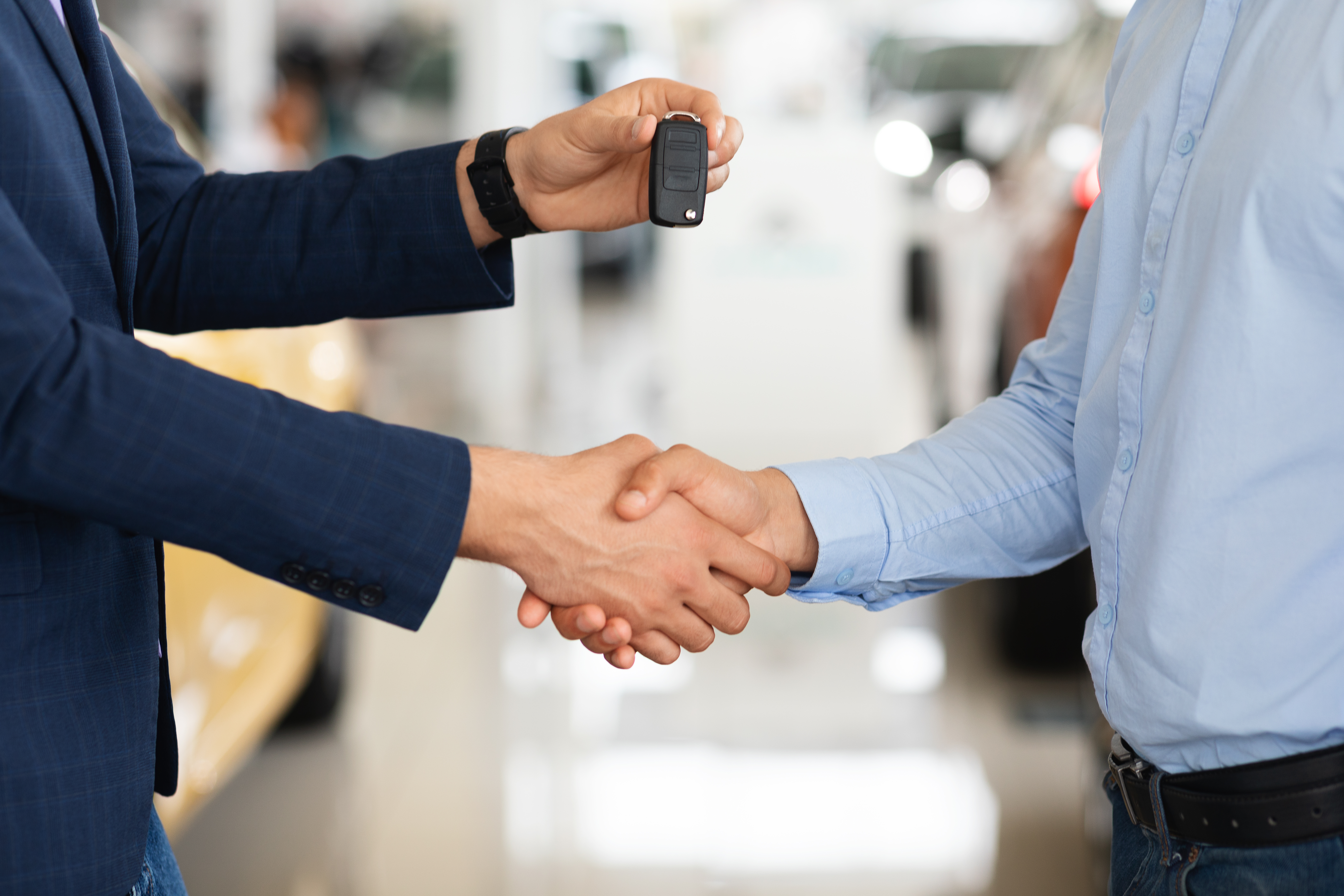 Closeup of customer and car dealer shaking hands